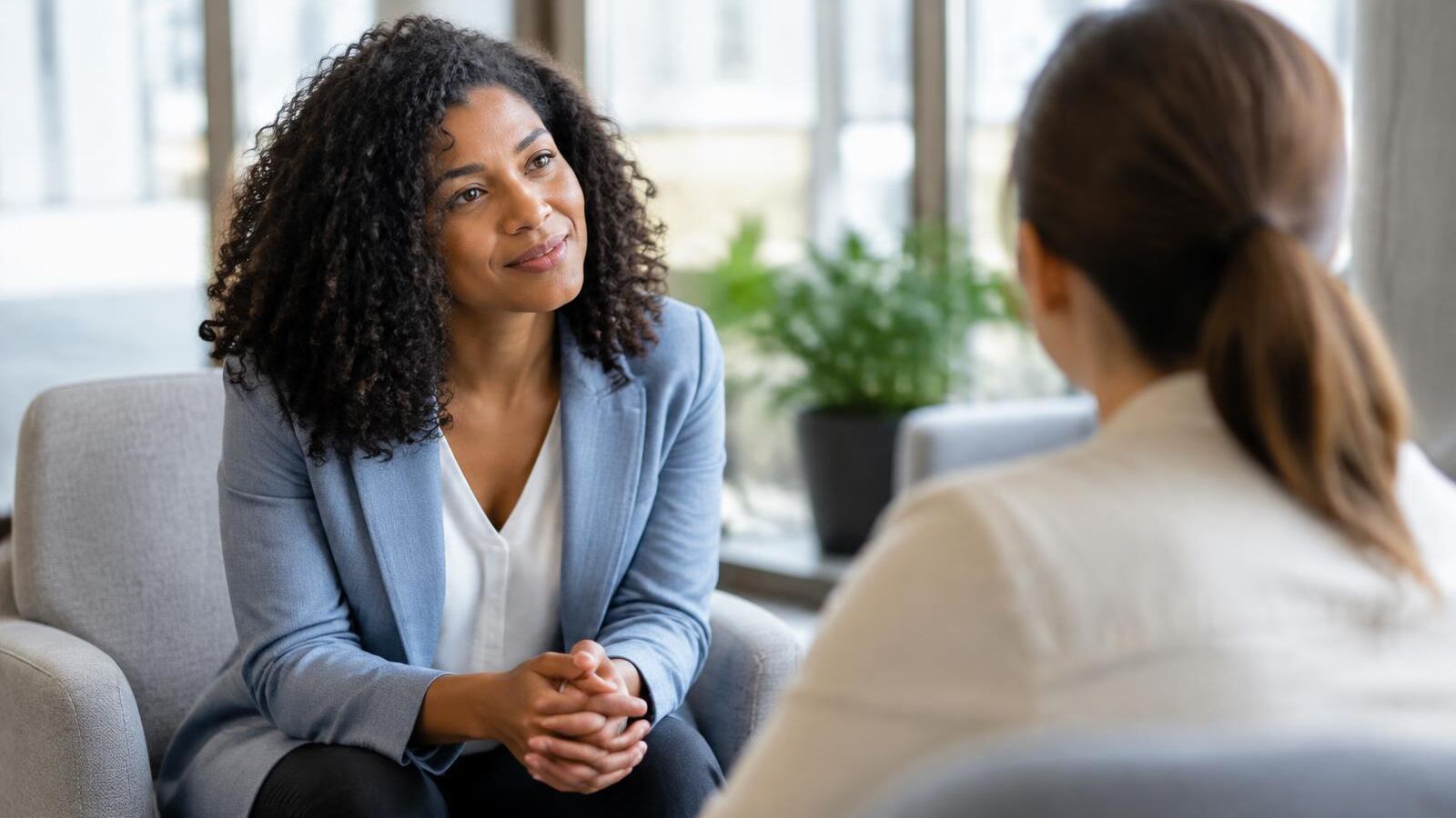 An HR leader listens calmly to an employee during a one-on-one conversation in a bright office